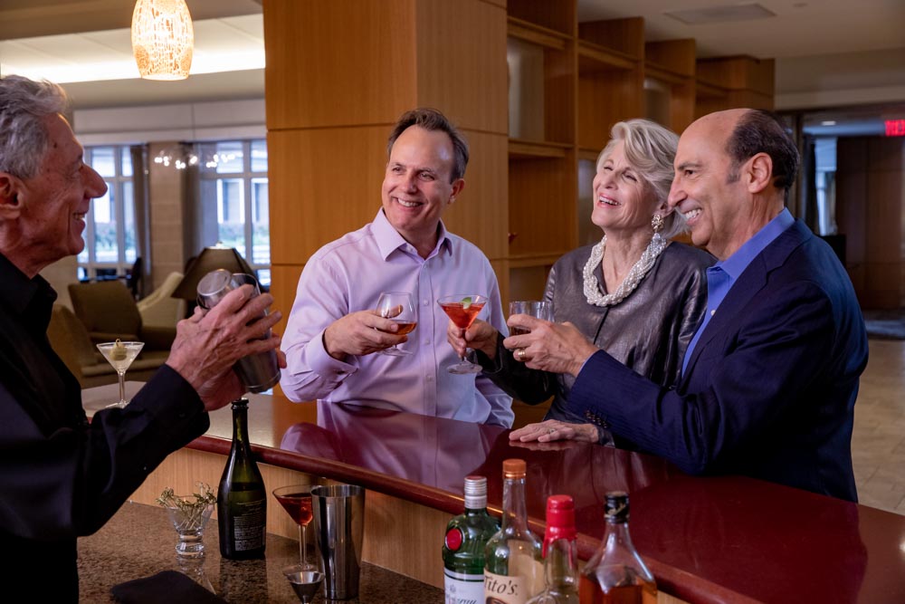 Seniors cheers with drinks in their hands at a community bar