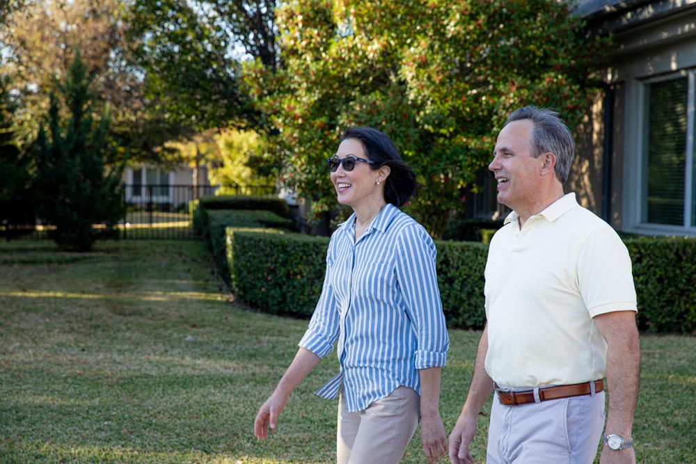 Senior couple walks the grounds at a senior living community