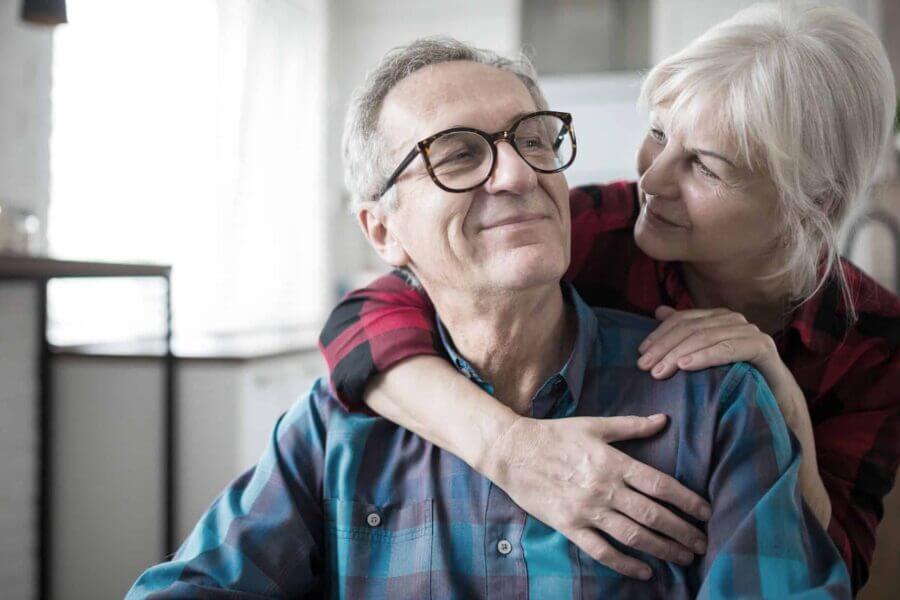 Portrait of happy senior woman embracing her husband