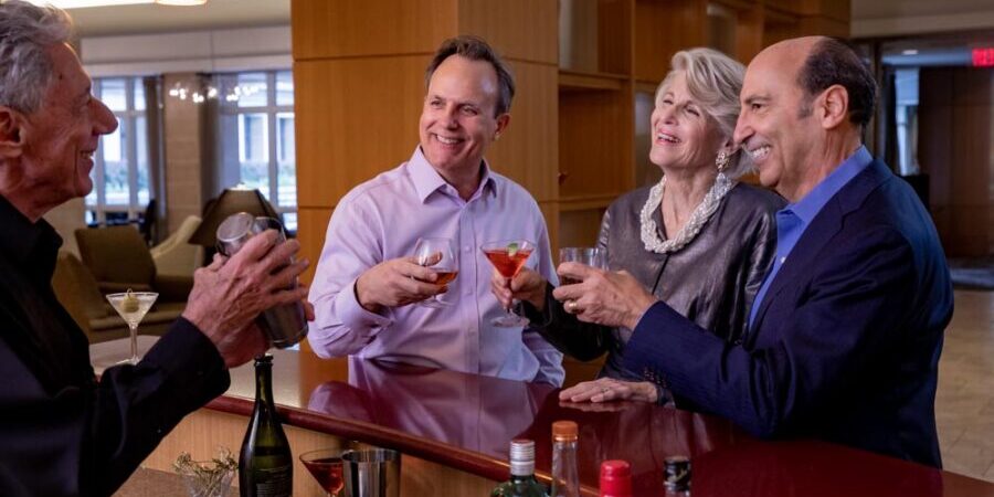 Seniors cheers with drinks in their hands at a community bar
