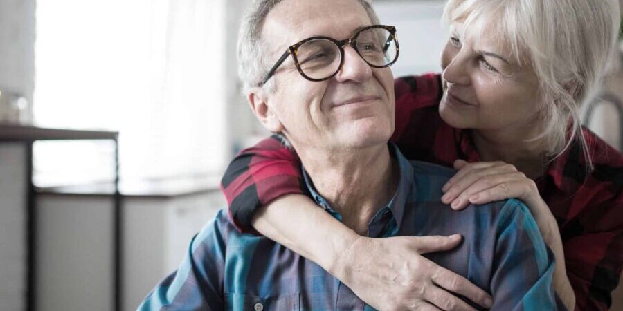 Portrait of happy senior woman embracing her husband