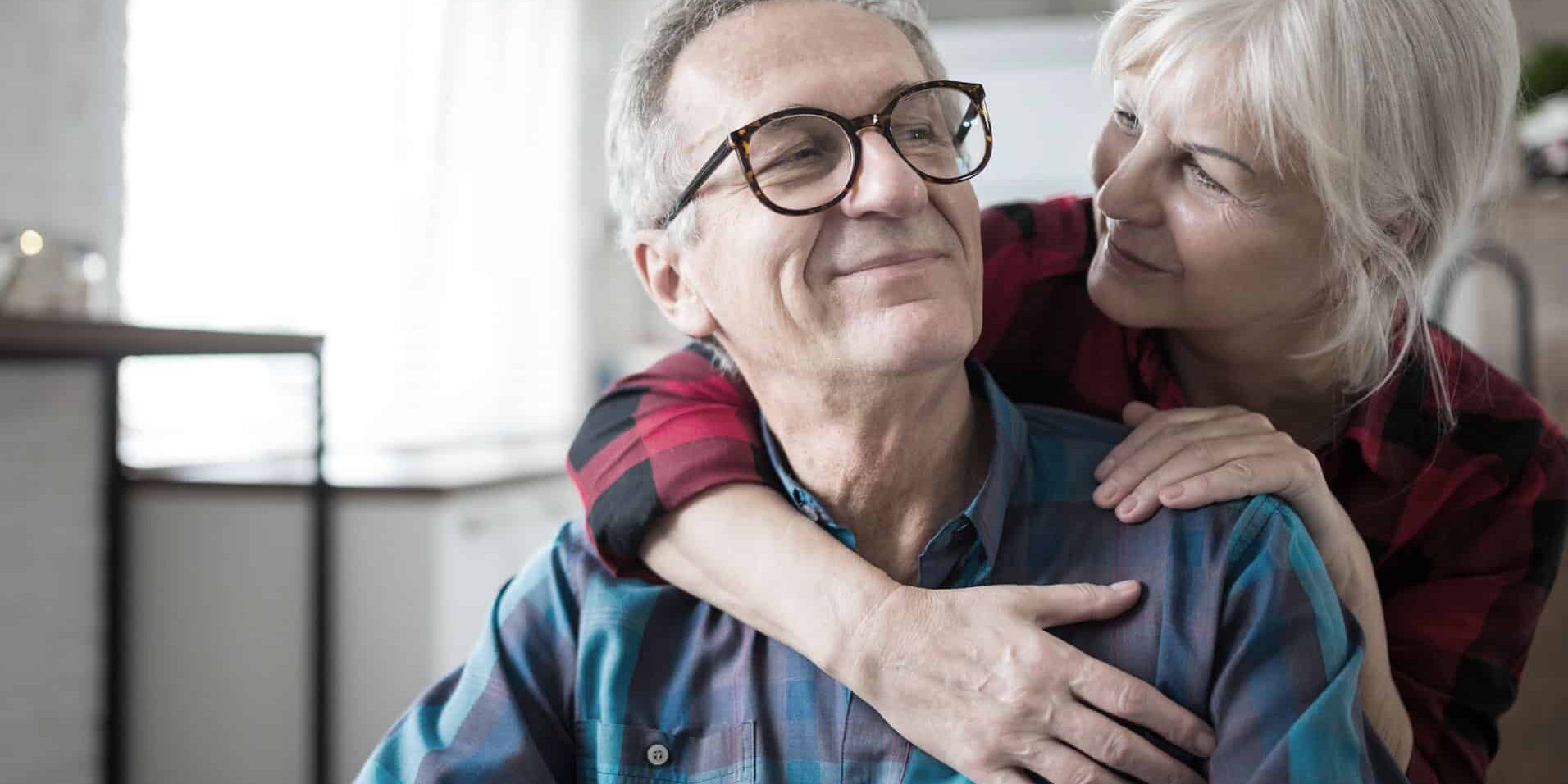 Portrait of happy senior woman embracing her husband