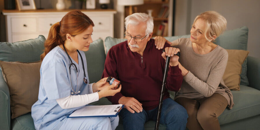 Nurse explaining medicine to senior couple at home