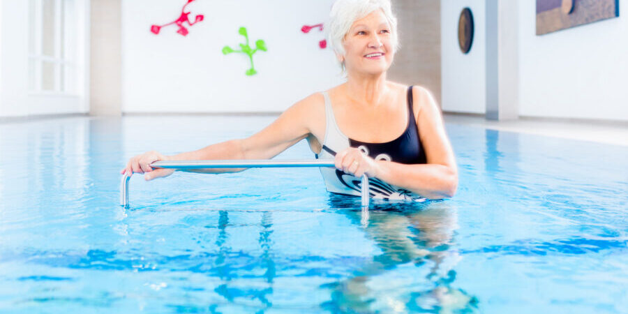 Senior woman in pool for aquatic therapy