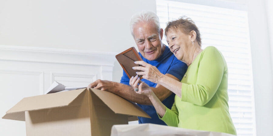 Senior couple packing things to downsize for senior living