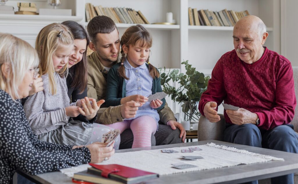 An older couple playing cards with their grandchildren