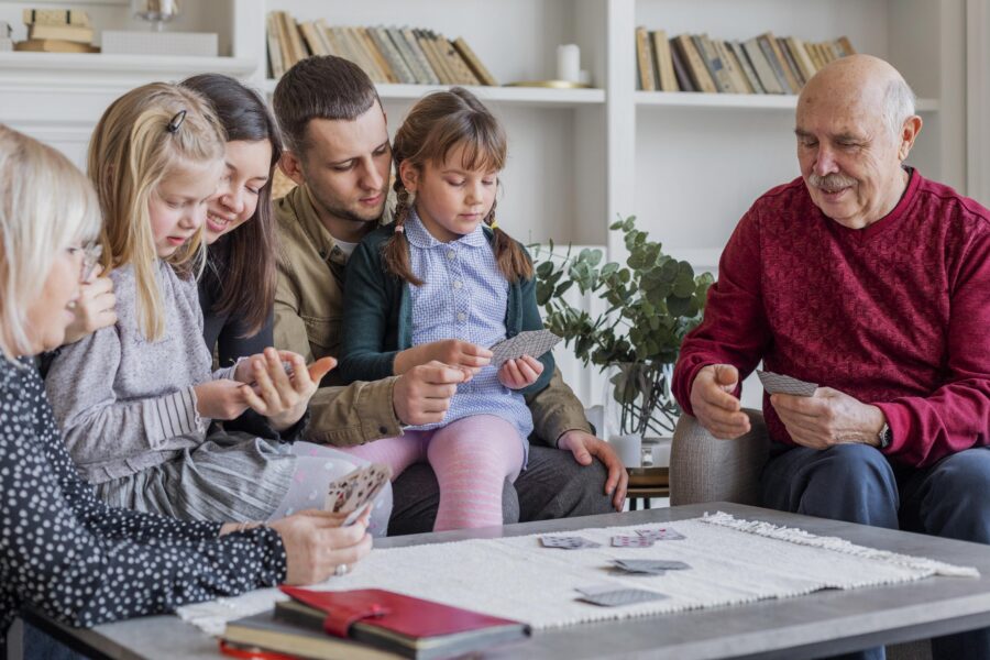 An older couple playing cards with their grandchildren