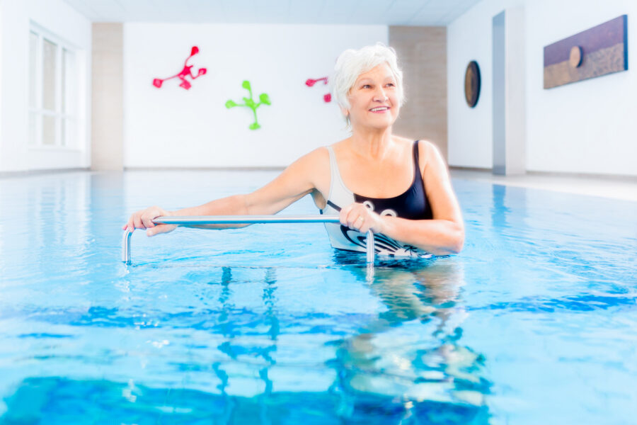 Senior woman in pool for aquatic therapy